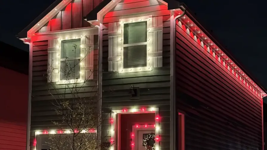 Red permanent roofline lights illuminating a home exterior